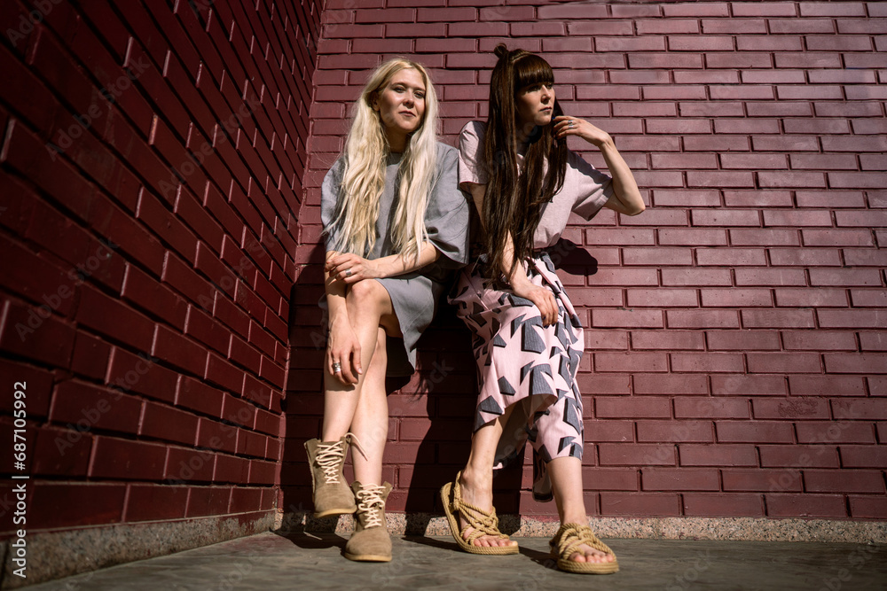 Fashion girls twins posing in nature Fashion girls twins posing in nature