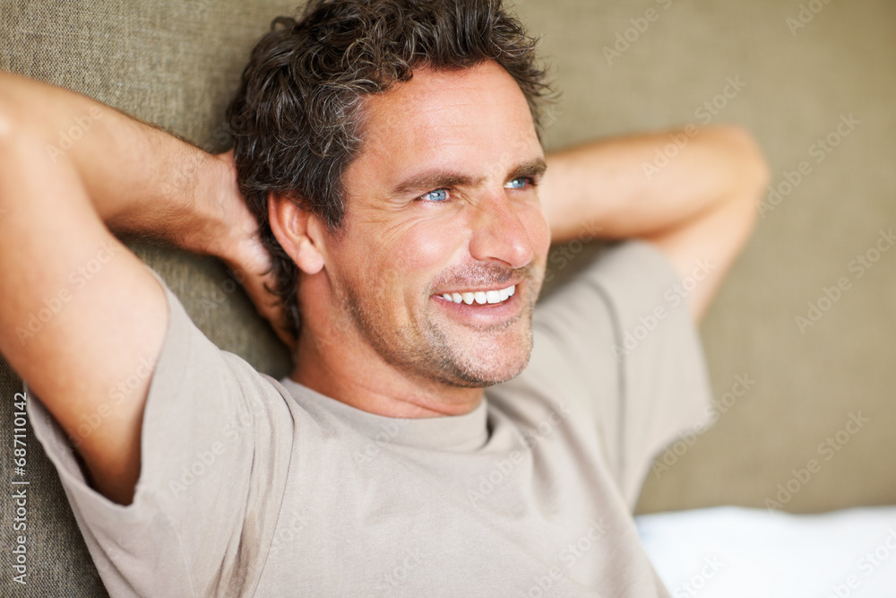 Face, smile and thinking with a man on a bed, hands behind head in his home to wake up in the morning. Relax, freedom or idea and a happy mature person the bedroom of an apartment with future vision