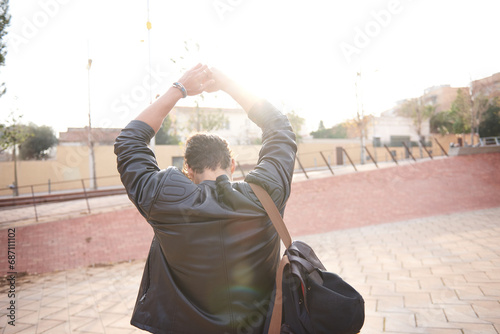 Man on his back walking and raising his arms for happiness photo