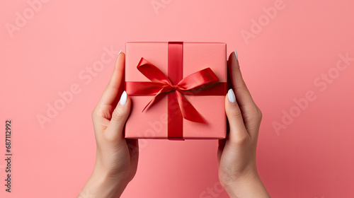 person holding a gift box, woman's hand holding red gift  box, Present for birthday, valentine day, Christmas, New Year. Congratulations background copy space. © Planetz