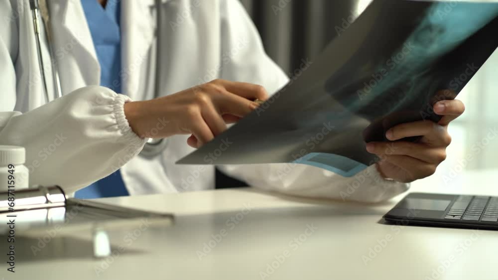 Medical doctor woman working on digital tablet and smartphone and healthcare doctor using x-ray film analyzed the results of medical reports. Medical doctor woman working on digital tablet and smartphone and healthcare doctor using x-ray film analyzed the results of medical reports.