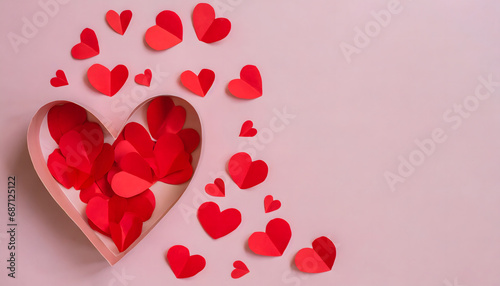 heart shaped paper box filled with and surrounded by red paper hearts on pastel pink background- love concept - valentines day