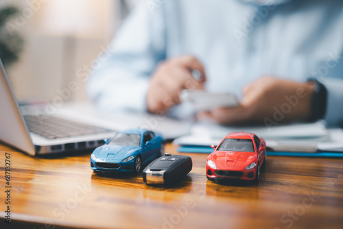 Toy Car In Front Of Businessman Calculating Loan. Saving money for car concept, trade car for cash concept, finance concept. photo