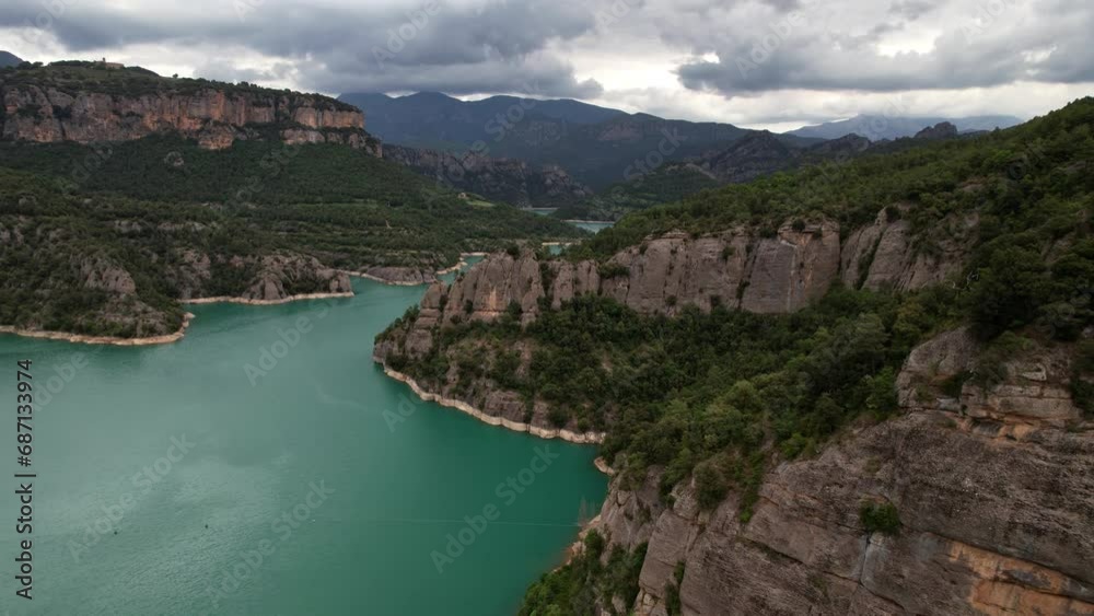 Dramatic clouds loom over a peaceful, emerald mountain lake. Dramatic clouds loom over a peaceful, emerald mountain lake.