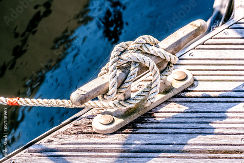 Photography close up of yacht or boat mooring rope tied around cleat in harbour
