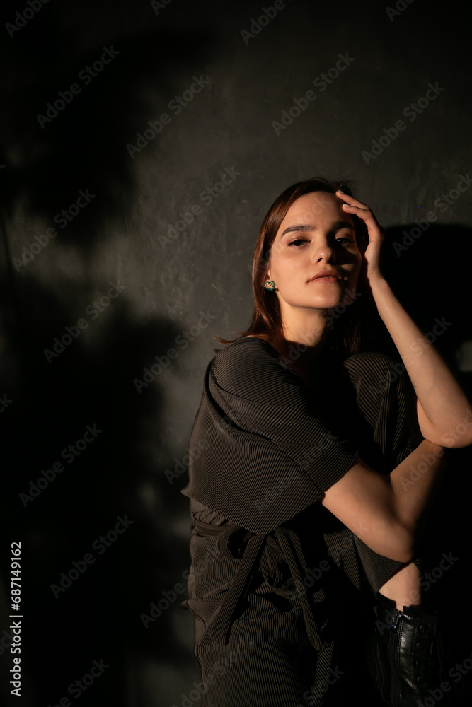 Woman in black clothes posing in a dark room Woman in black clothes posing in a dark room