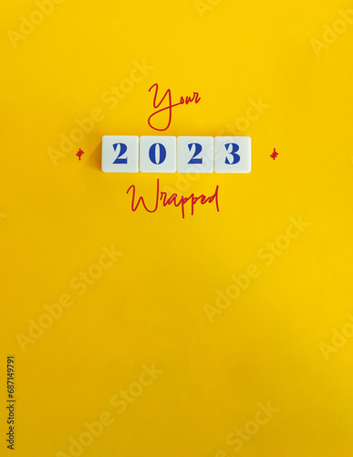 Year 2023 Recapitulation, Wrapping, Summarising. Concept Image. Cursive Text and Block Letter Tiles on Yellow Background. photo
