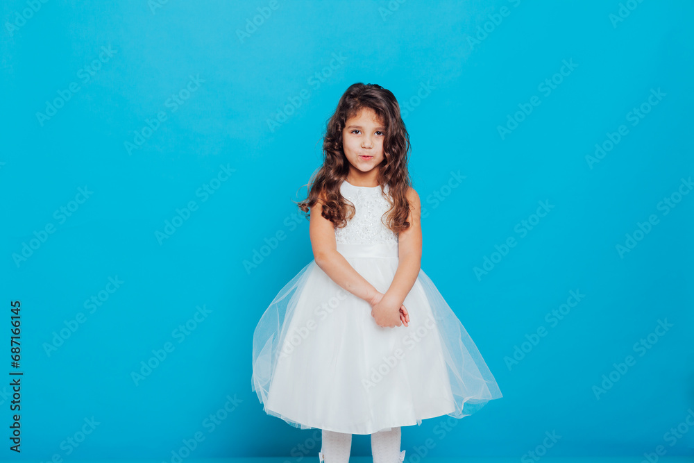 Girl in white elegant dress on a blue background Holiday Girl in white elegant dress on a blue background Holiday