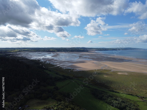 Aerial photograph over the breathtaking fields by Red Wharf Bay in Anglesey, Wales, UK with village of Benllech in background at low tide photo