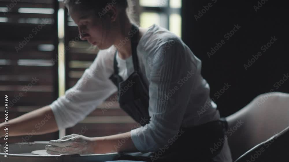 Ceramic tableware: the process of creating. The hands of the potter: a woman potter uses special tools and makes stein.