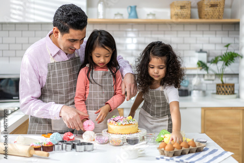 Portrait of enjoy happy love asian family father with little asian girl daughter child play and having fun cooking food together with baking cookie and cake ingredient in kitchen