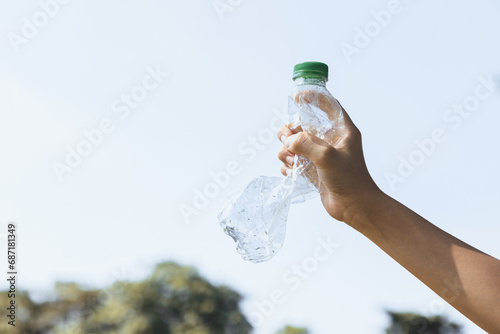 Recyclable plastic bottle held in hand up on sky background. Hand holding plastic waste for recycle reduce and reuse concept to promote clean environment with effective recycling management. Gyre photo