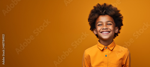 Un beau petit garçon afro-américain, heureux et souriant, arrière-plan coloré uni