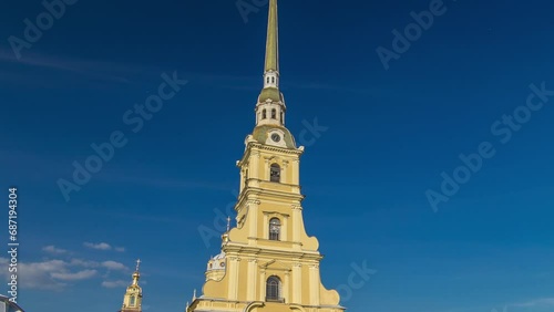 Citadel's Charm: Peter and Paul Fortress Timelapse Hyperlapse. Petropavlovskaya Krepost, Iconic Landmark in St. Petersburg, Russia. Front View of Facade Against a Blue Cloudy Sky photo