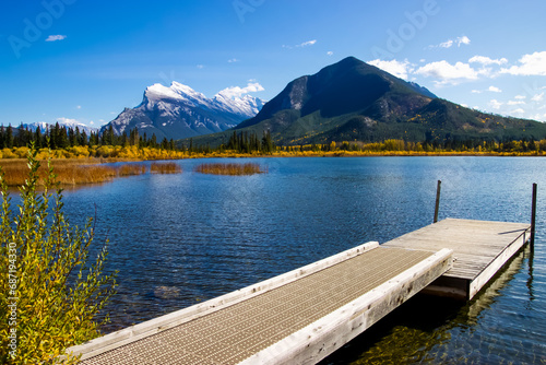 A wooden dock in Vermillion Lake with Rundle mountain in the background. photo