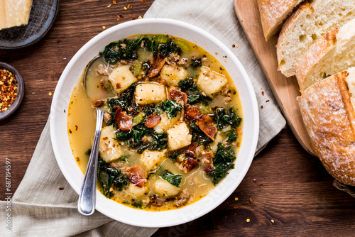 Creamy Zuppa Toscana soup served with sourdough bread. photo