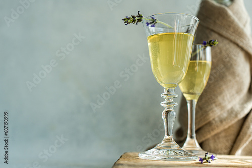 Close-up of two glasses of  Limoncello with lavender flowers and a bottle on a wooden chopping board
