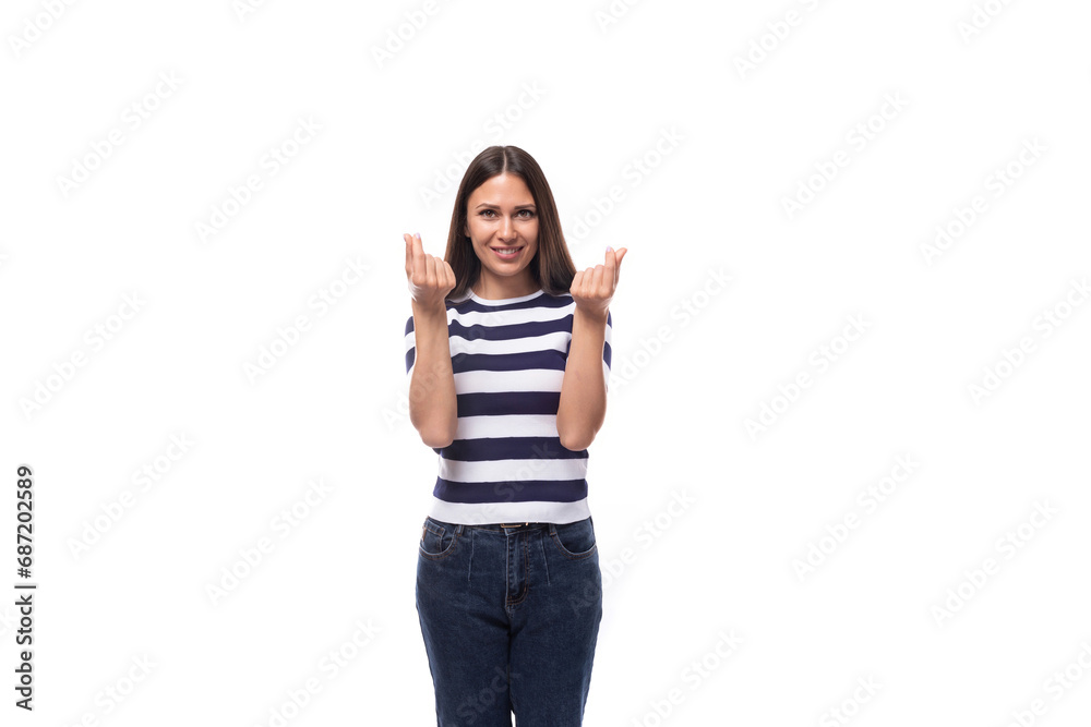 attractive young caucasian brunette woman in a striped t-shirt points with her hands to the advertising space on a white background with copy space attractive young caucasian brunette woman in a striped t-shirt points with her hands to the advertising space on a white background with copy space