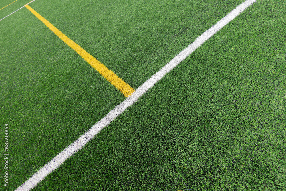 Green artificial grass turf soccer football field background with white and yellow line boundary. Top view Green artificial grass turf soccer football field background with white and yellow line boundary. Top view