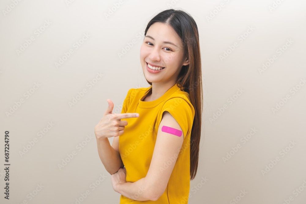 Healthcare of Covid-19, coronavirus vaccination, happy asian young woman hand pointing, showing at bandage, plaster on arm, getting vaccine immunity, giving injection influenza to protection pandemic. Healthcare of Covid-19, coronavirus vaccination, happy asian young woman hand pointing, showing at bandage, plaster on arm, getting vaccine immunity, giving injection influenza to protection pandemic.