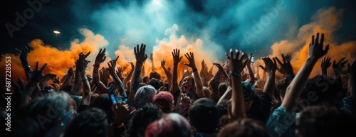 Amidst the vibrant music and billowing clouds, a sea of outstretched hands unites the concertgoers in a powerful display of collective energy and euphoria photo