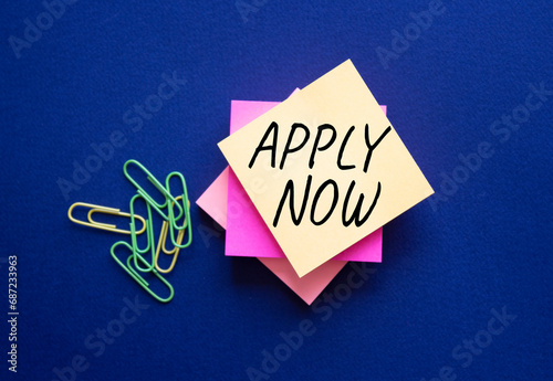 Apply now symbol. Concept word Apply now on steaky note. Beautiful deep blue background. Business and Apply now concept. Copy space photo