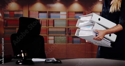 Midsection Of Female Lawyer Carrying Stack Of Ring Binders