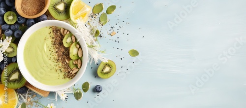 Superfood smoothie bowl with matcha green tea chia flax and pumpkin seeds bee pollen granola coconut flakes kiwi and blueberries displayed from above Copy space image Place for adding text or d photo