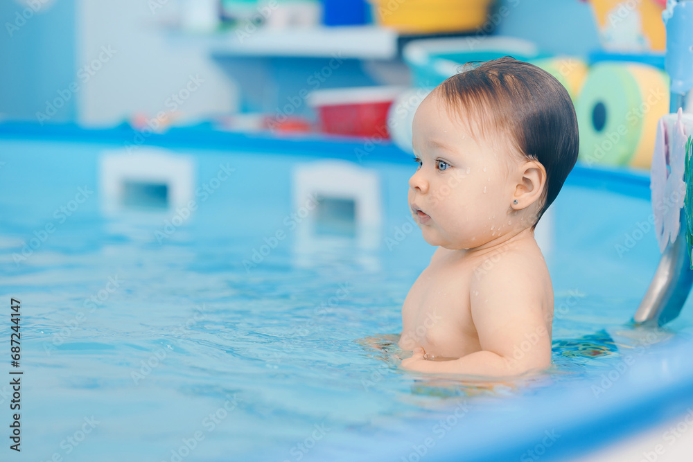Portrait happy baby girl in swimming pool, teaching small swimmer. Concept healthcare sport for infant Portrait happy baby girl in swimming pool, teaching small swimmer. Concept healthcare sport for infant