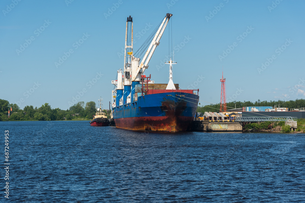 a marine vessel carries out loading at the pier. against the background of blue sky