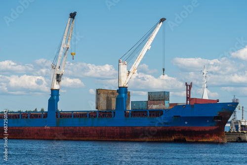 a marine vessel carries out loading at the pier. against the background of blue sky