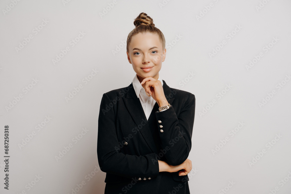 Professional woman in black blazer, thinking pose, white backdrop Professional woman in black blazer, thinking pose, white backdrop