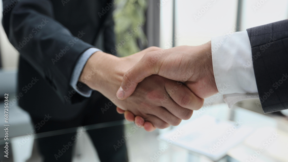 Building a strong business network. two businessmen shaking hands in a modern office.