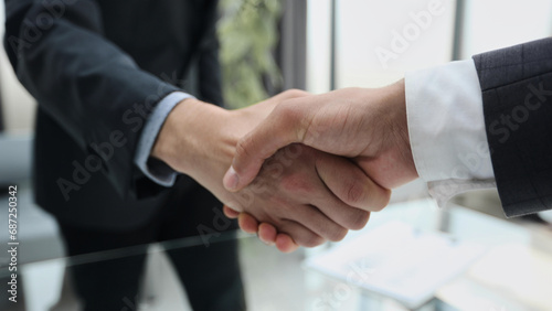 Building a strong business network. two businessmen shaking hands in a modern office.