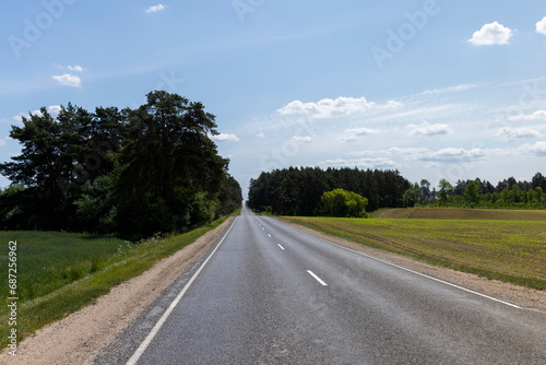 paved road with trees in the forest in sunny weather © rsooll