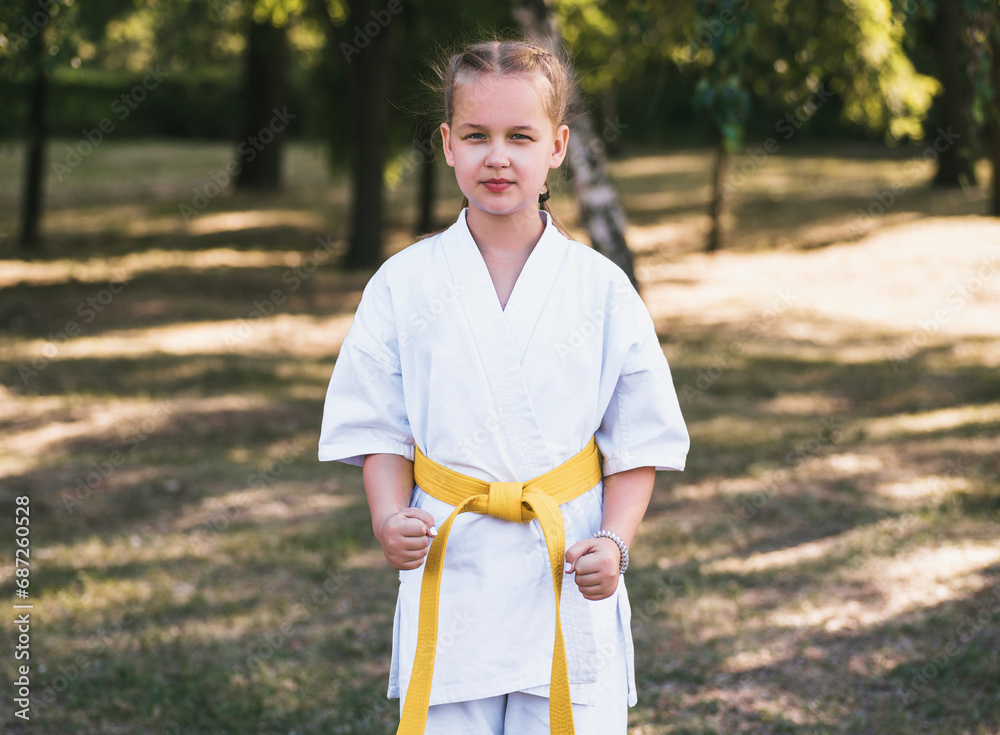 Girl doing martial arts outdoors at nature background. Active teenager