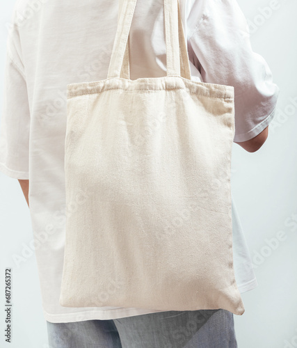 Bild auf Leinwand Carrying eco textile shopper, cotton tote bag, standing back view