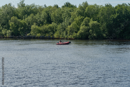a man is fishing in the river sitting in a rubber boat