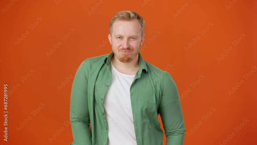 Positive man dancing in dance studio on orange background Positive man dancing in dance studio on orange background