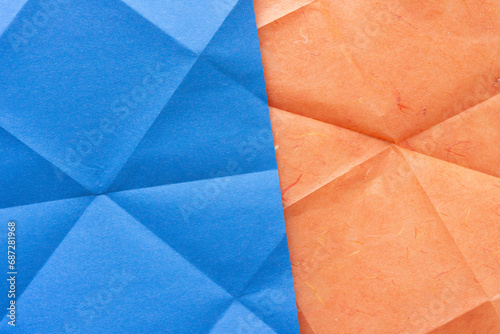 background composed of blue and orange paper with geometric or triangular folded pattern
