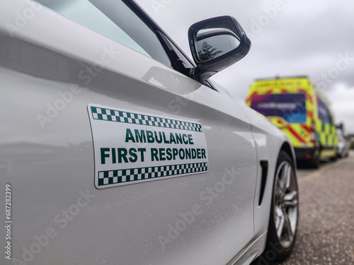 Ambulance first responder attending a medical emergency. UK volunteer community first responder car with an ambulance in the background