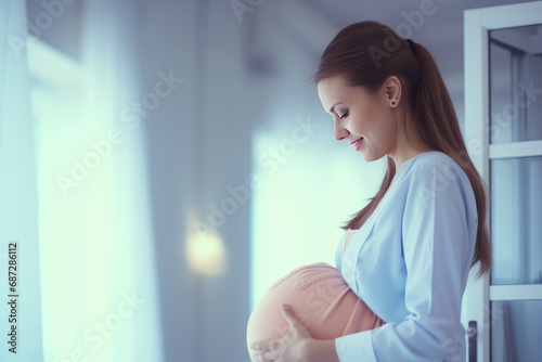 Happy joyful pregnant woman in a maternity modern hospital, big belly, twins. Gynecological services for pregnant women, pregnancy planning center, medical services. photo
