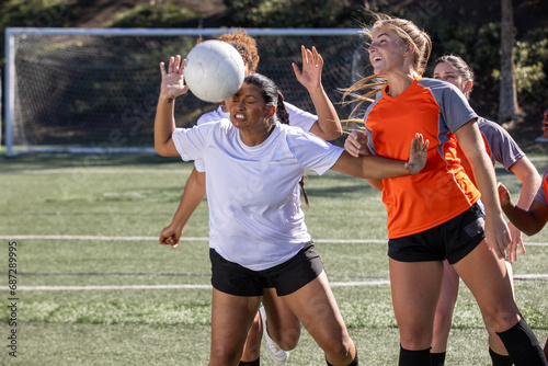 Female soccer players play in an intense and competitive game on the field outside.  photo