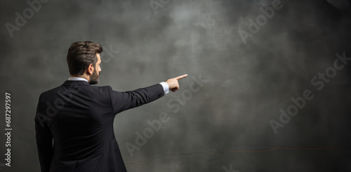 A man with his back turned, pointing towards an empty space on a white background, silently guiding attention and sparking curiosity, copyspace