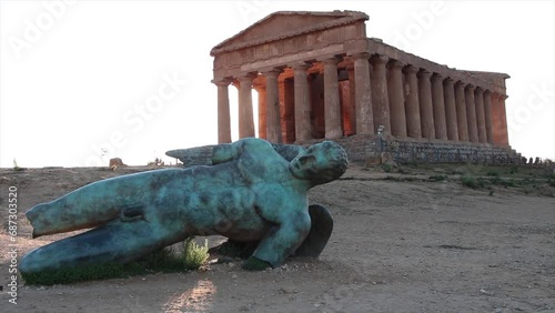 agrigento sicily italy ancient temple of concordia wide shot with damaged broken statue of man lying on its side in foreground photo