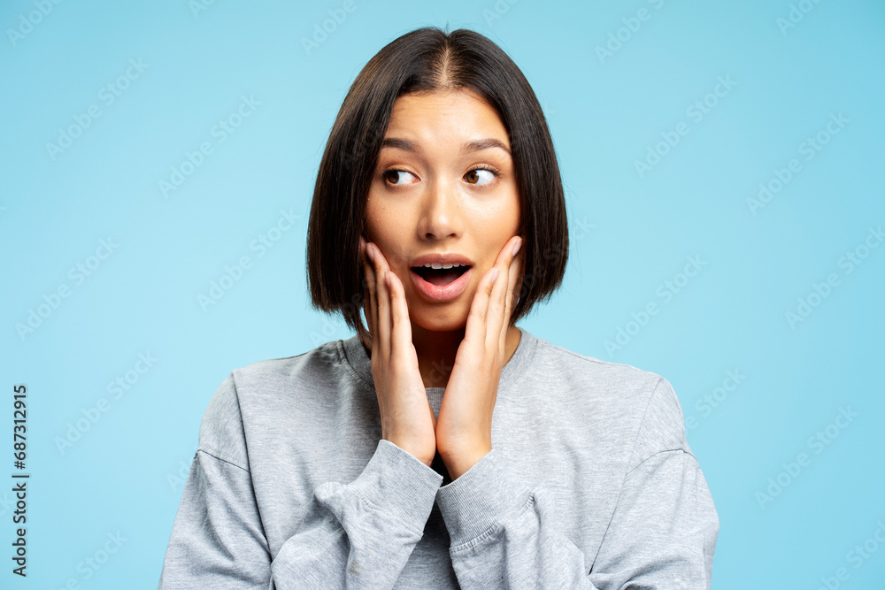 Portrait of shocked attractive Asian woman with stylish hairstyle looking away choosing something Portrait of shocked attractive Asian woman with stylish hairstyle looking away choosing something