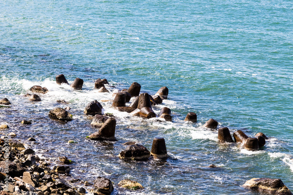 Naklejka premium travel to Georgia - Tetrapods breakwaters on Black Sea coast on border between Turkey and Georgia in Sapri village on sunny autumn day
