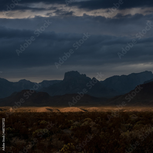 Dark Storm Clouds Gather Over Chisos Mountains With Sliver Of Sun Light In The Valley