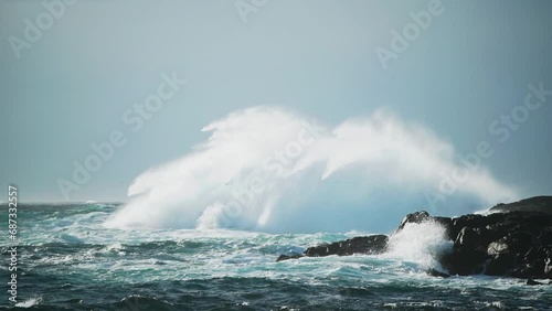 Mighty wave crashing into the rocks on the coastline. Dangerous sea during windy day at Vesterålen, Norway. photo