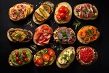 set of different bruschettas with prosciutto, salmon, tomatoes and avocado on a dark background. view from above
